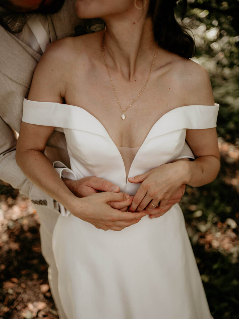 Inniger Moment bei der Hochzeit: Bräutigam umarmt seine Braut in einem eleganten Kleid