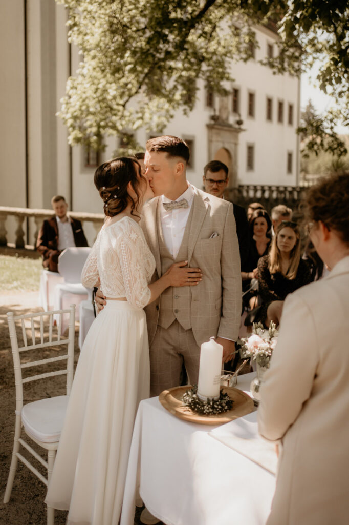 Christian Messner fotografiert den emotionalen Hochzeitskuss vor Gästen im Garten