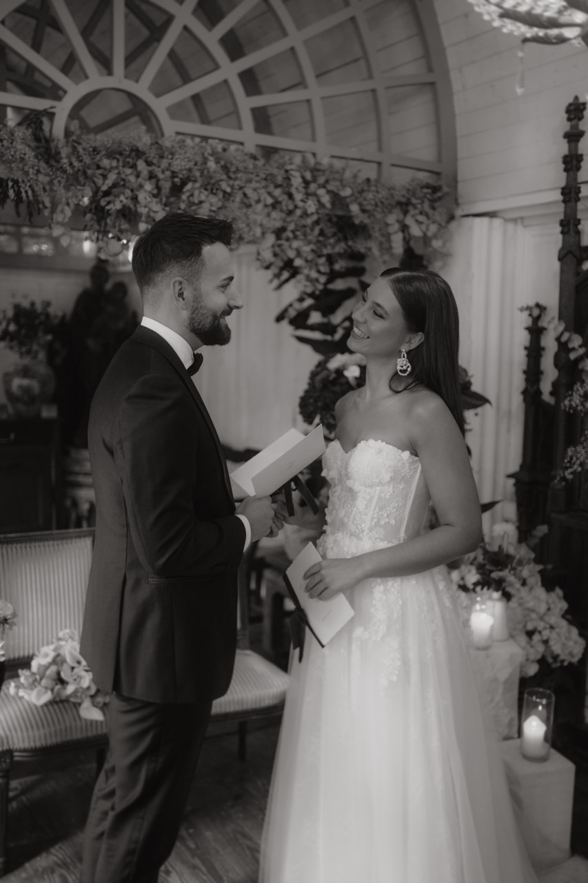 Emotionaler Augenblick, in dem Braut und Bräutigam sich gegenseitig ihre Gelübde vorlesen und sich dabei tief in die Augen sehen.