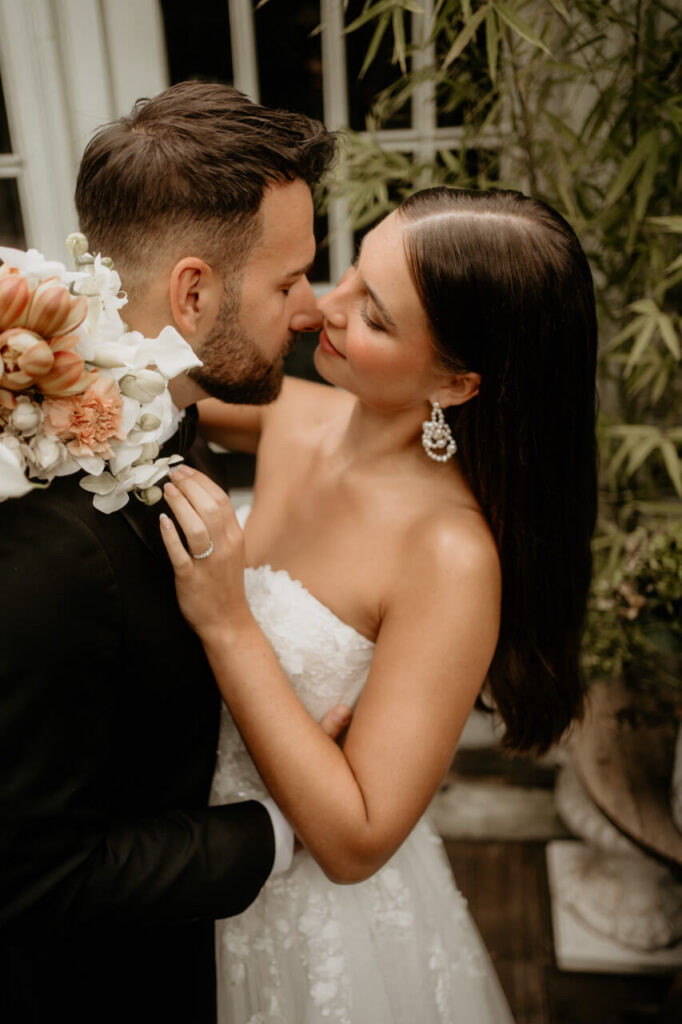 Inniger Moment zwischen Braut und Bräutigam, die sich liebevoll umarmen und kurz davor sind, sich zu küssen.