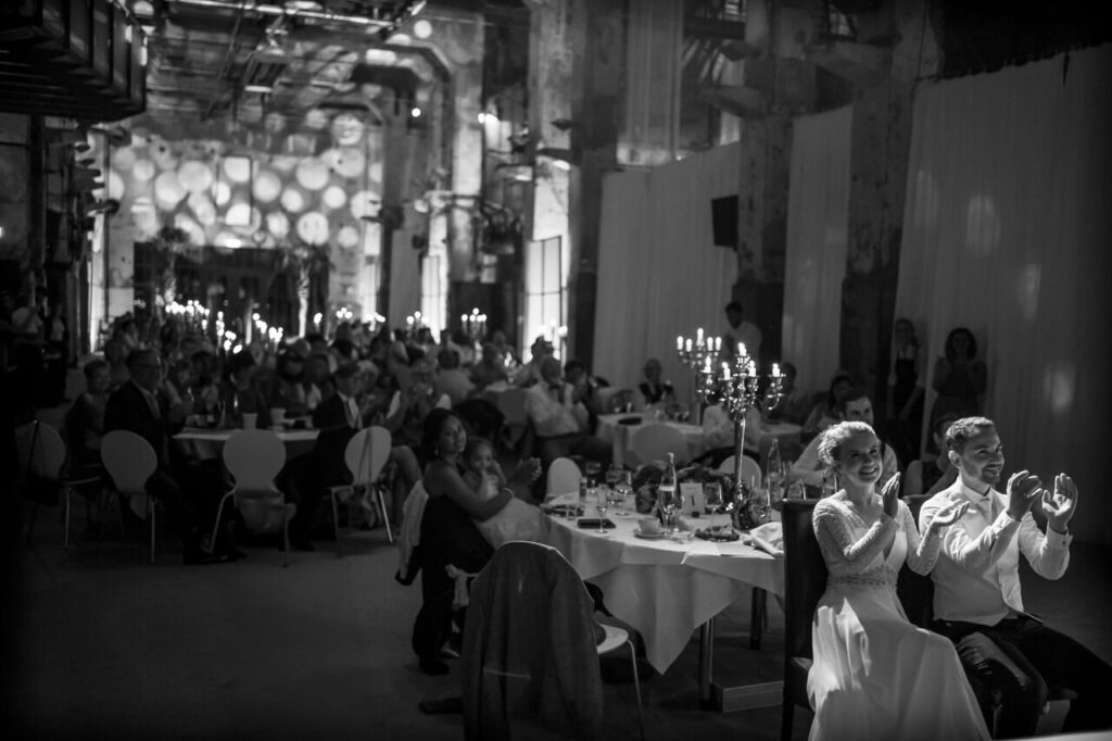 Hochzeitsfotograf hält emotionale Reaktion des Brautpaares während einer Rede bei Kerzenschein fest