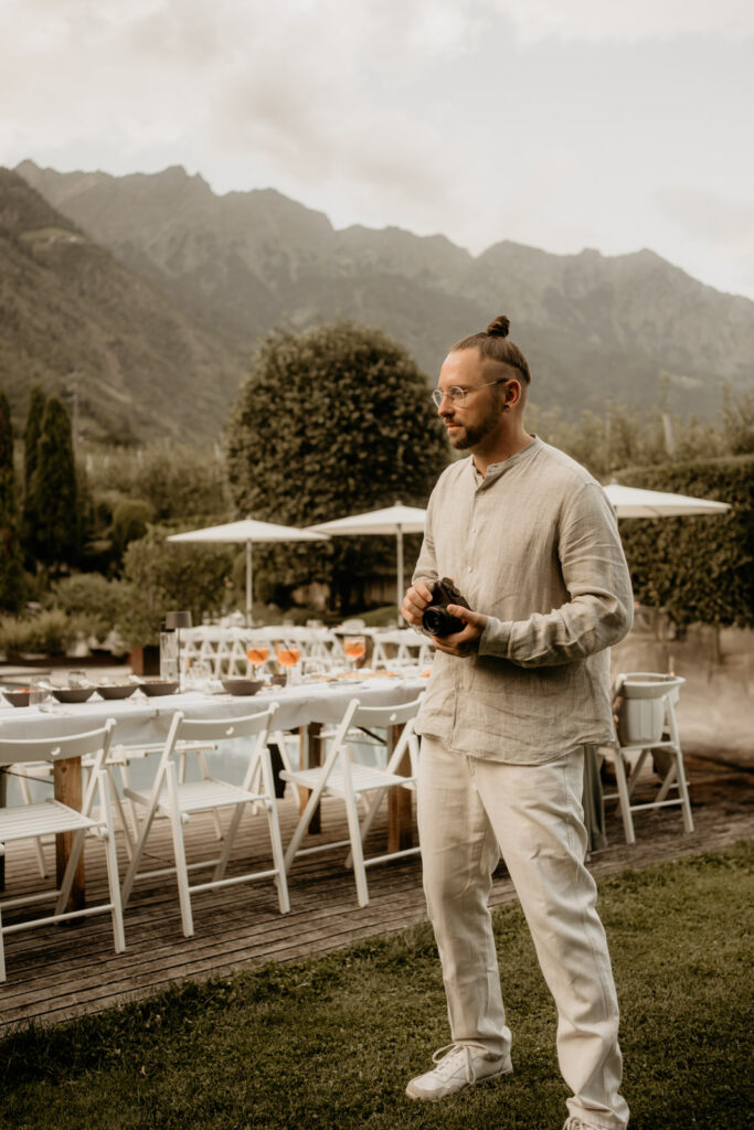 Hochzeitsfotograf bei einer stilvollen Outdoor-Hochzeit in den Bergen – mit Kamera in der Hand und Blick fürs Detail.
