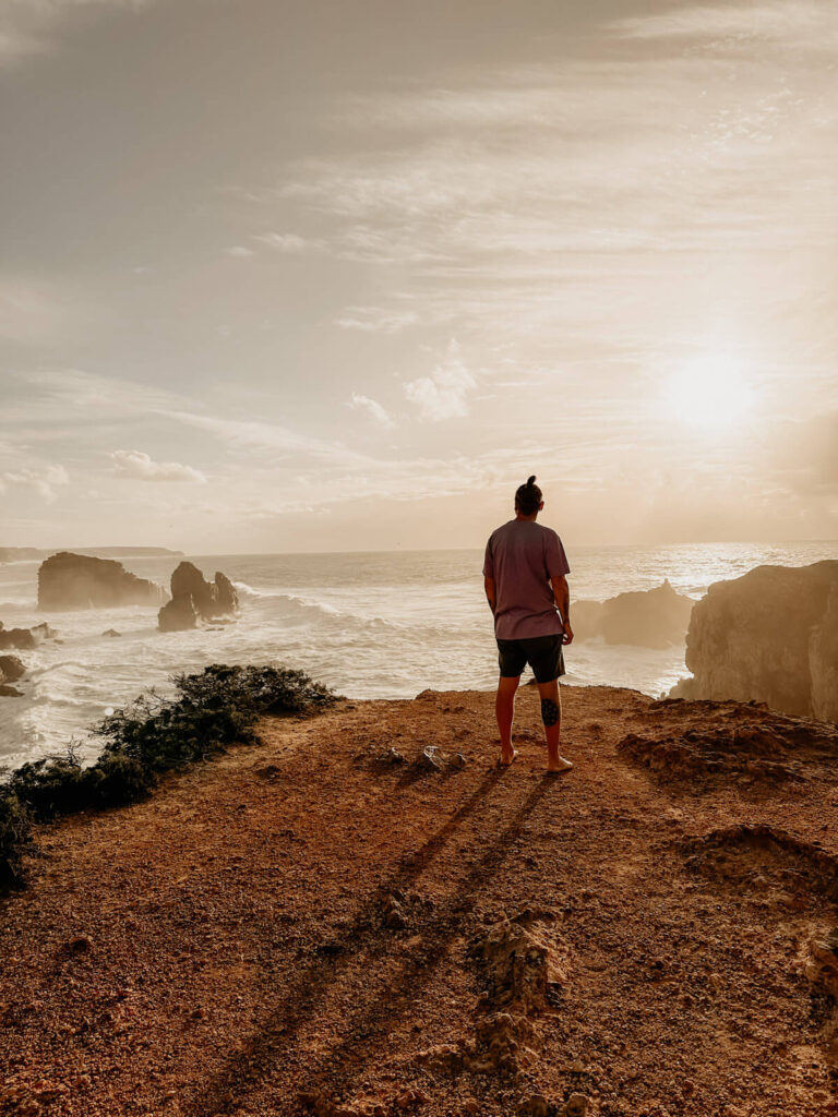 Christian Messner auf einer Felskante bei Sonnenuntergang – ein stiller Moment an der Küste Portugals