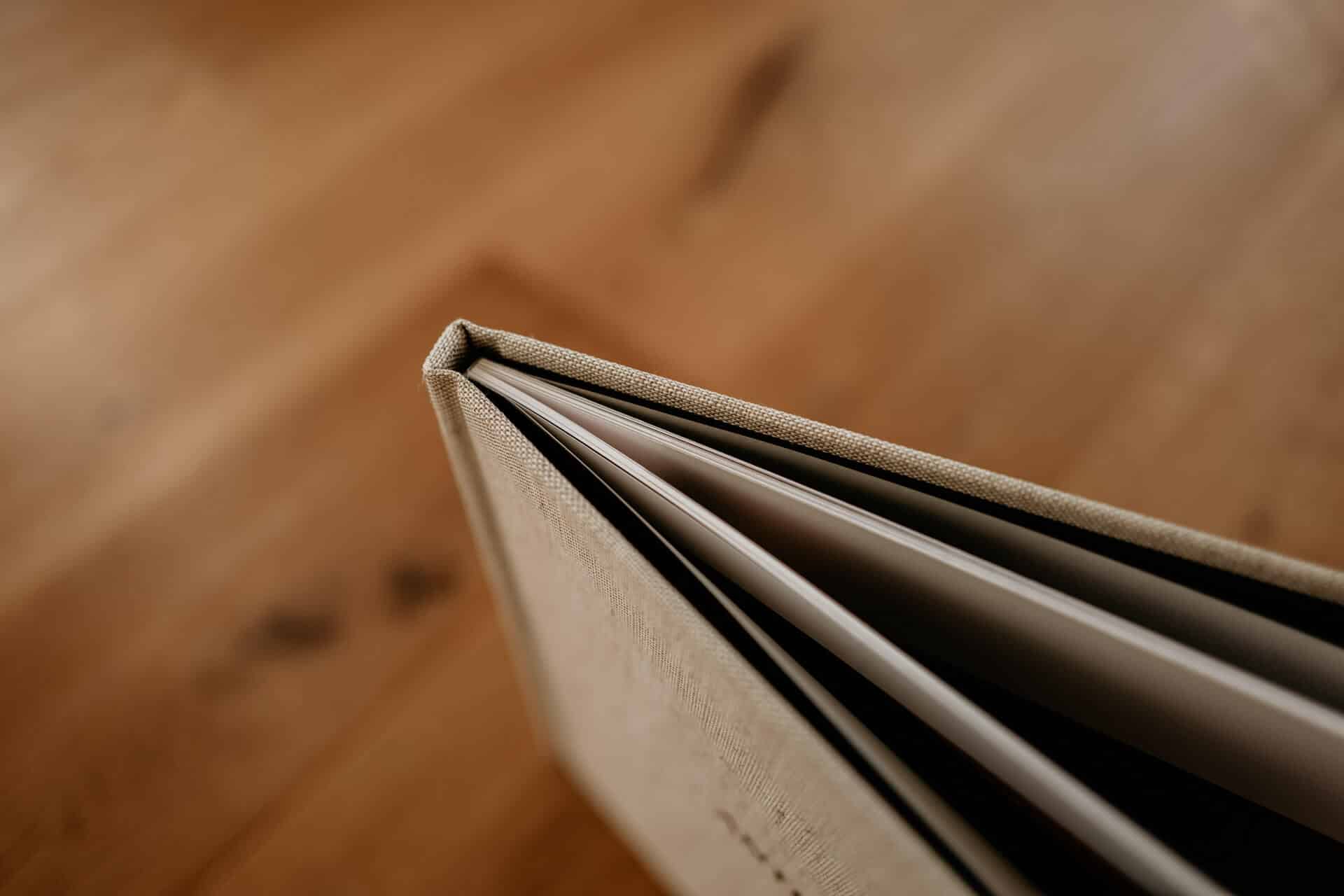 Nahaufnahme eines edlen Hochzeitsalbums mit strukturierter Oberfläche und Einblick in die Seiten – liebevoll umgesetzt von Christian Messner