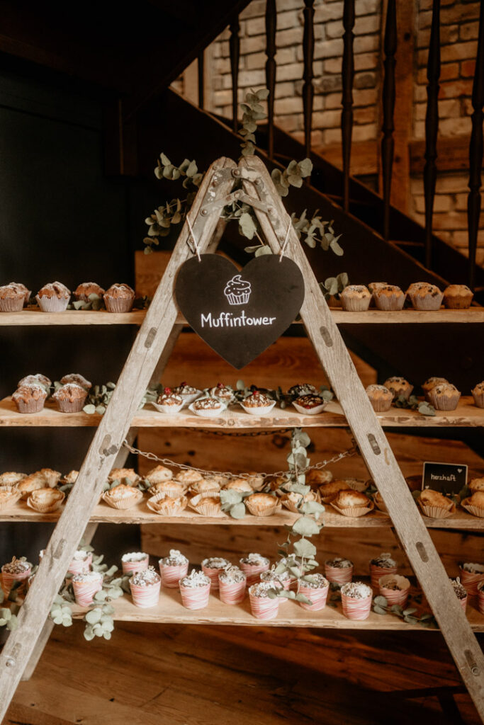 Kreativ gestalteter Muffintower mit verschiedenen Muffins und Cupcakes als Teil des Hochzeitsbuffets