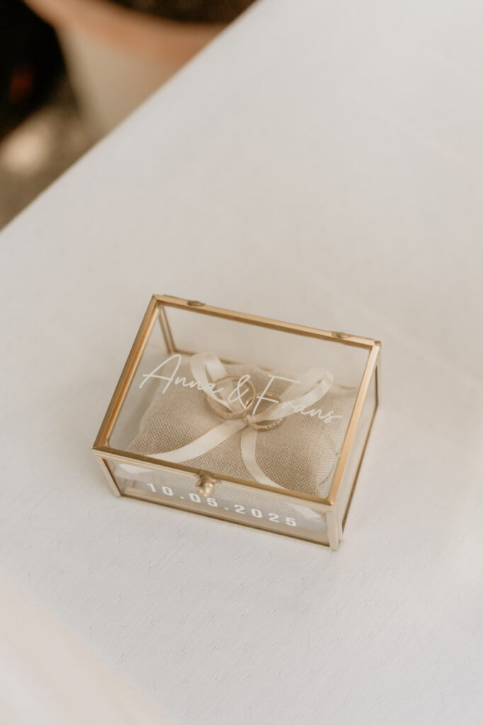 Detailaufnahme einer goldenen Ringbox mit den Namen Anna & Frans und dem Hochzeitsdatum